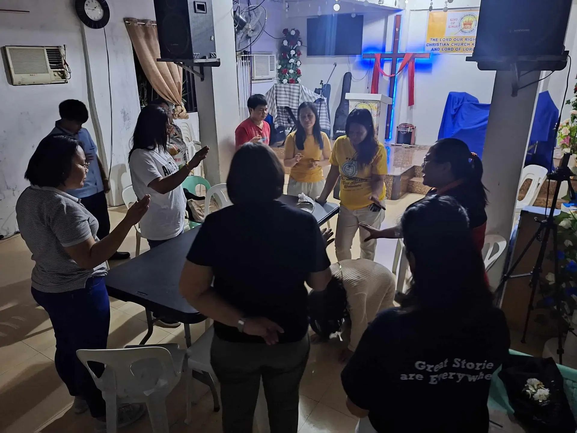 A group laying hands and praying over a woman in a church in the Philippines