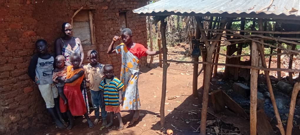 A mother and her children outside their home in Uganda