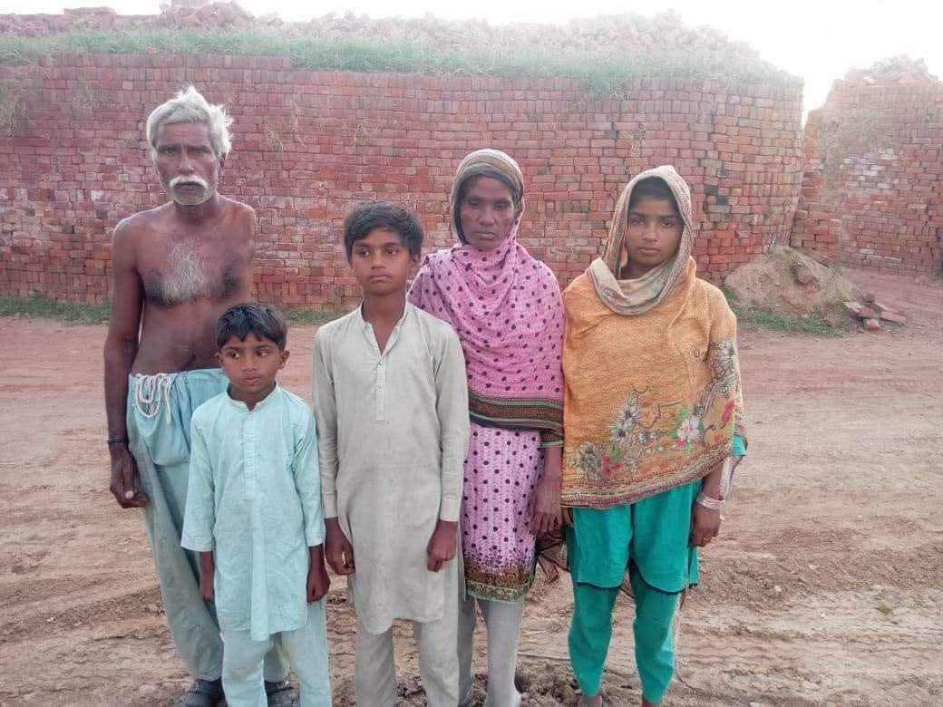 A family standing in front of a brick kiln in Punjab