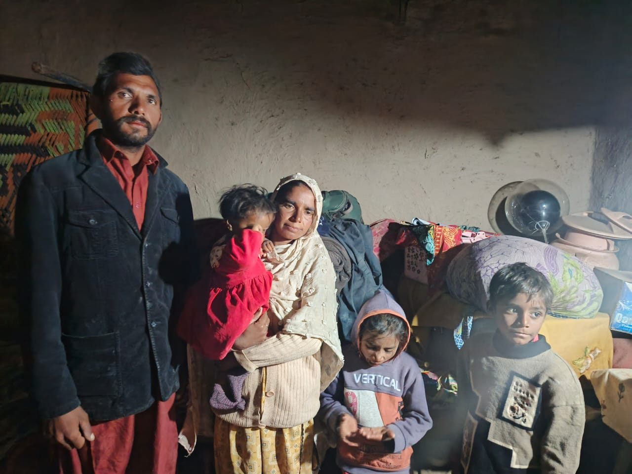 A brick-kiln family inside their one-room home in Punjab