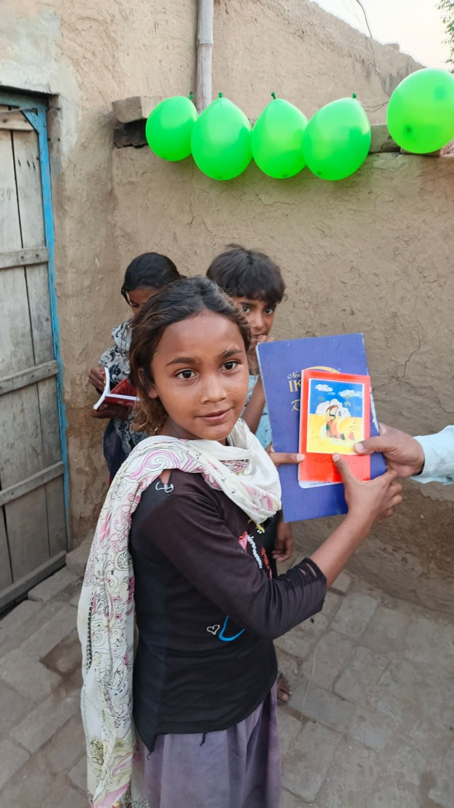 A girl receiving a Bible and a children’s Bible in Punjab