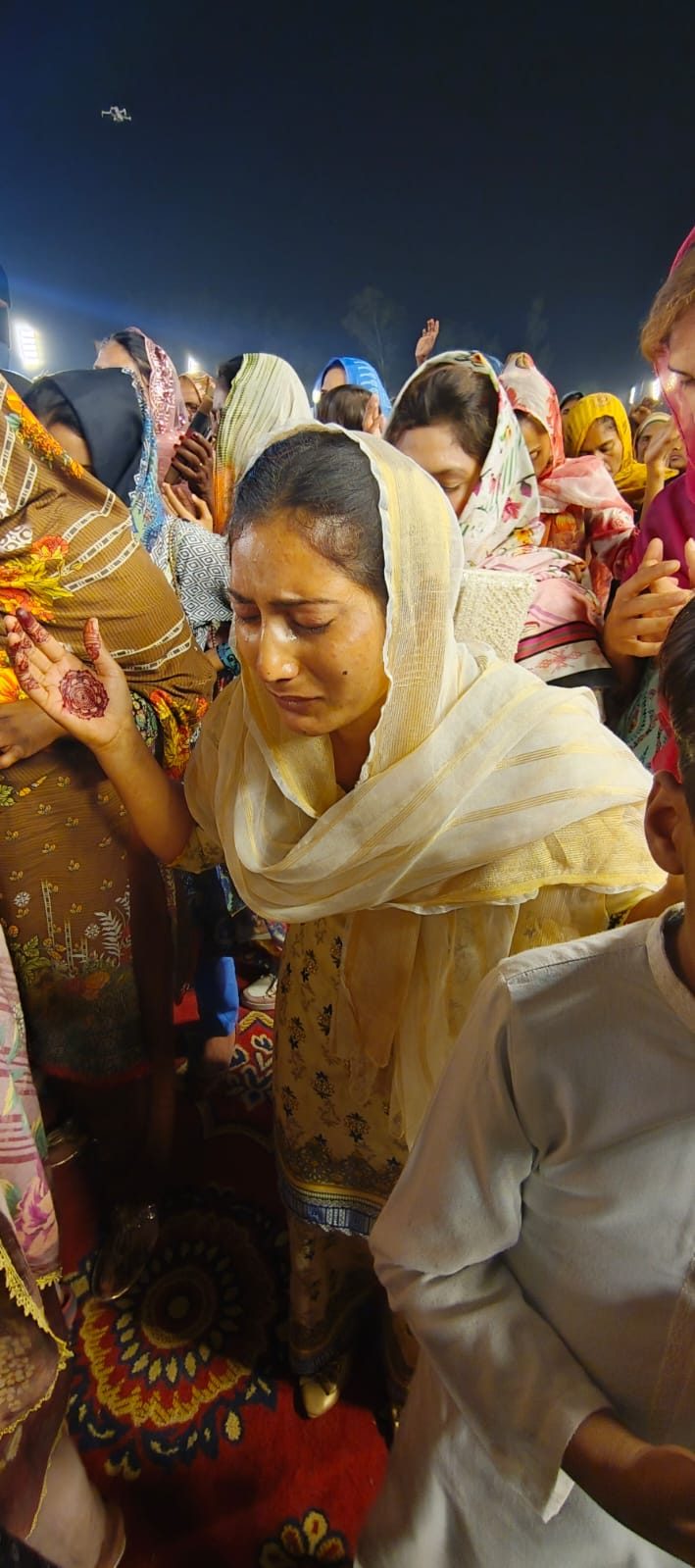 A woman weeping in worship at a prayer gathering in Raiwind